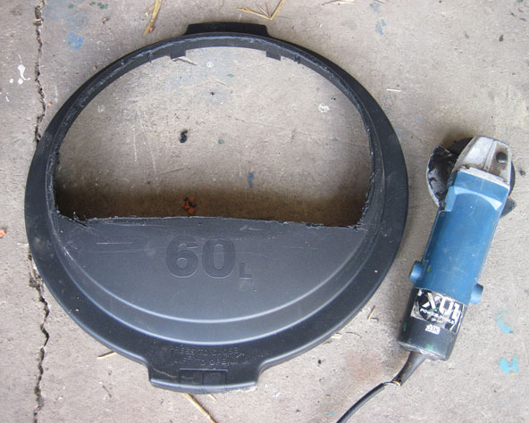 LargepPhoto of rubbish bin lid with entrance section cut out.