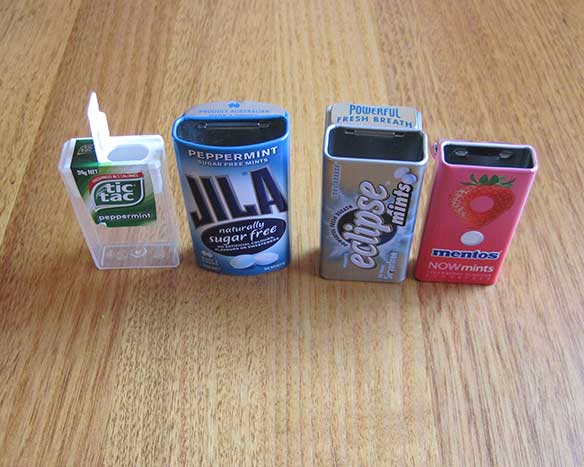 Large photo of four mint boxes with their flip top lids open.